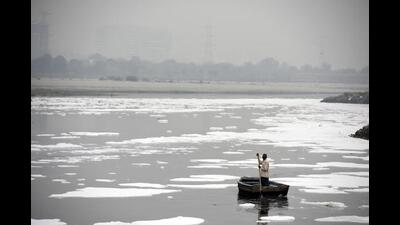 A man rows a boat in the heavily polluted waters of the Yamuna River, at Kalindi Kunj New Delhi, India, on November 25, 2020. (HT PHOTO)