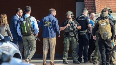 Kentucky Governor Andy Beshear speaks with police deploying at the scene of a mass shooting near Slugger Field baseball stadium in downtown Louisville, Monday. (via REUTERS)