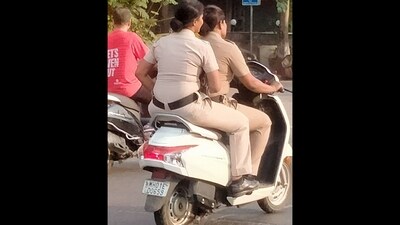 Mumbai cops riding on a scooty without helmets. (Twitter/@RahulB__007) Mumbai cops riding on a scooty without helmets. (Twitter/@RahulB__007)