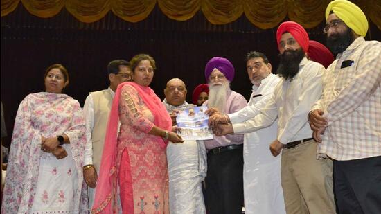 Punjab local bodies minister Inderbir Singh Nijjar (fourth from right) handing over allotment letter to an applicant in Ludhiana on Monday. (Manish Kalia/HT)