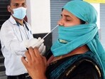 A healthcare worker collects a nasal swab sample of a passenger for the COVID-19 testing. A healthcare worker collects a nasal swab sample of a passenger for the COVID-19 testing.