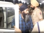 Punjab Police personnel bring Papalpreet Singh to Amritsar airport. 