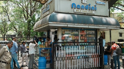 Customers at a Nandini milk shop, amid reports claiming the entry of Amul products in Karnataka market, in Bengaluru, Monday, April 10, 2023. (PTI) Customers at a Nandini milk shop, amid reports claiming the entry of Amul products in Karnataka market, in Bengaluru, Monday, April 10, 2023. (PTI)