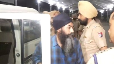 Punjab Police personnel bring Papalpreet Singh to Amritsar airport. (ANI)