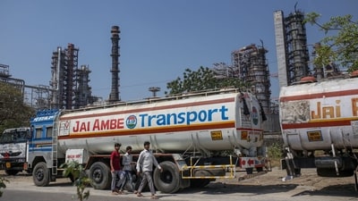 People walk by an oil refinery operated by Bharat Petroleum Corp. Ltd., in Mumbai, India. (Bloomberg) People walk by an oil refinery operated by Bharat Petroleum Corp. Ltd., in Mumbai, India. (Bloomberg)