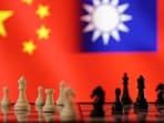 Chess pieces are seen in front of displayed Chinese and Taiwanese flags in this illustration taken