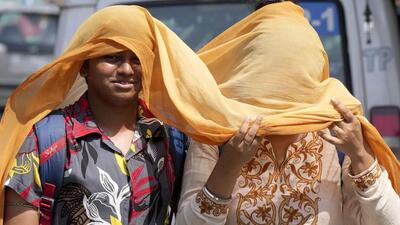 Pedestrians cover themselves with a scarf to protect them from the searing heat. (PTI photo) Pedestrians cover themselves with a scarf to protect them from the searing heat. (PTI photo)
