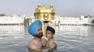 A young devotee taking a dip in the sarovar at Golden Temple, Amritsar, on the occasion of Baisakhi, (Sameer Sehgal/HT)