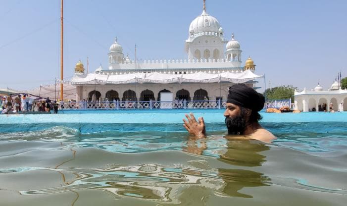 A devotee taking a dip at the sarovar at Takhat Sri Damdama Sahib in Talwandi Sabo in Bathinda. (Sanjeev Kumar/HT)