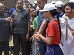West Bengal Governor CV Ananda Bose allows a student to join him as security personnel during the school children's visit to Raj Bhawan on the occasion of Bengali New Year.
