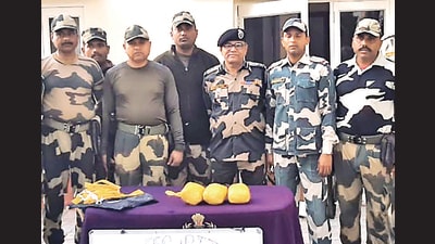 BSF personnel showing three packets of heroin dropped by a drone at border in Amritsar on Saturday. (HT photo)