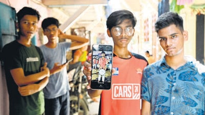 Mumbai, India - April 15, 2023: Friends of Swapnil Dhumal showing his photograph on their mobile phone at Santosh Nagar, Goregaon, who died after a bus carrying young male and female members of a traditional music troupe fell into a gorge on the old Mumbai-Pune highway in Raigad district of Maharashtra early today, in Mumbai, India, on Saturday, April 15, 2023. (Photo by Vijay Bate/HT Photo) (HT PHOTO) Mumbai, India - April 15, 2023: Friends of Swapnil Dhumal showing his photograph on their mobile phone at Santosh Nagar, Goregaon, who died after a bus carrying young male and female members of a traditional music troupe fell into a gorge on the old Mumbai-Pune highway in Raigad district of Maharashtra early today, in Mumbai, India, on Saturday, April 15, 2023. (Photo by Vijay Bate/HT Photo) (HT PHOTO)