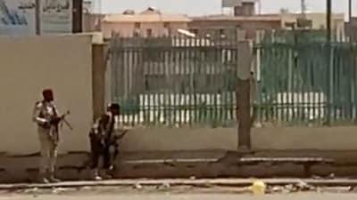 Two armed men seen on a street in Kartoum, Sudan April 15, 2023, in this screen grab obtained from a social media video. Mohammadkhair Abdualrhman/via REUTERS