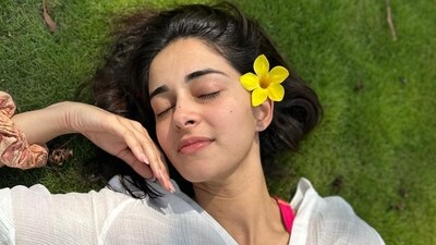 Ananya Panday, in a photo, lay on the ground enjoying the weather as she closed her eyes. She wore a white shirt over her bikini top. The actor also tucked in a yellow flower behind her ear. Ananya Panday, in a photo, lay on the ground enjoying the weather as she closed her eyes. She wore a white shirt over her bikini top. The actor also tucked in a yellow flower behind her ear.