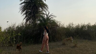 Ananya Panday also shared her candid picture as she walked amid the greenery with two dogs around her. Ananya Panday also shared her candid picture as she walked amid the greenery with two dogs around her.