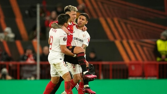 Sevilla's Marcos Acuna, left, and Sevilla's Gonzalo Montiel, right, help Manchester United's Lisandro Martinez off the pitch during the Europa League first leg quarterfinal soccer match between Manchester United and Sevilla at the Old Trafford stadium in Manchester, Thursday, April 13, 2023. (AP Photo/Dave Thompson) (AP)