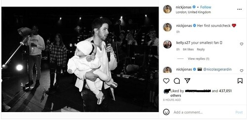 Nick shared a black and white photo of himself holding Malti.
