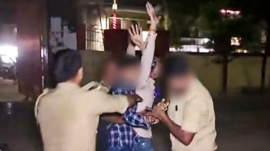 Policemen attempt to apprehend an assailant who opened fire at Gangster-turned-politician Atiq Ahmed and his brother Ashraf Ahmed while they were being taken for a medical checkup, in Prayagraj, Saturday. (PTI)