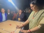 The image shows Smriti Irani aiming to pocket a piece. The image shows Smriti Irani aiming to pocket a piece.