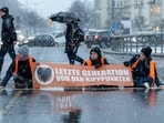 Activists of the "Last Generation" stick themselves on a street during snowfall in Dresden, Germany, and want to draw attention to the compliance with the climate targets.