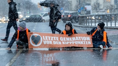 Activists of the "Last Generation" stick themselves on a street during snowfall in Dresden, Germany, and want to draw attention to the compliance with the climate targets. (File/ AP) Activists of the "Last Generation" stick themselves on a street during snowfall in Dresden, Germany, and want to draw attention to the compliance with the climate targets. (File/ AP)