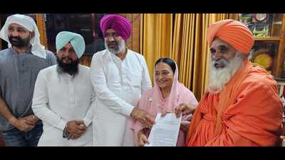 Rajya Sabha member of Parliament Balbir Singh Seechewal hands over a list of environmental issues to Congress candidate Karamjit Kaur Chaudhary. (HT Photo)