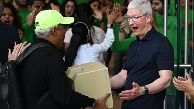 Chief Executive Officer of Apple Tim Cook (R) reacts as a man shows him a Macintosh SE computer during the opening of Apple's first retail store in India, in Mumbai on April 18, 2023. (AFP) Chief Executive Officer of Apple Tim Cook (R) reacts as a man shows him a Macintosh SE computer during the opening of Apple's first retail store in India, in Mumbai on April 18, 2023. (AFP)