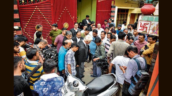 Locals gather after a crude bomb was hurled near the residence of Daya Shankar Mishra, the lawyer of slain gangster-turned-politician Atiq Ahmad, in Prayagraj on Tuesday. (PTI)