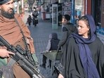 United Nations In Afghanistan: A Taliban fighter stands guard as a woman walks past in Kabul, Afghanistan. United Nations In Afghanistan: A Taliban fighter stands guard as a woman walks past in Kabul, Afghanistan.