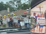 The image, taken from the viral video, shows a woman getting a grand welcome from her neighbours after beating cancer. The image, taken from the viral video, shows a woman getting a grand welcome from her neighbours after beating cancer.