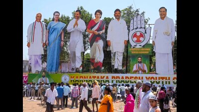 Congress supporters walk past giant cut-outs of senior party leaders in Karnataka’s Kolar. (PTI) Congress supporters walk past giant cut-outs of senior party leaders in Karnataka’s Kolar. (PTI)