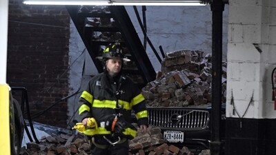 New York Parking Collapse: A member of the Fire Department of New York (FDNY) walks at the scene of a parking garage that collapsed in lower Manhattan, New York City. (AFP)