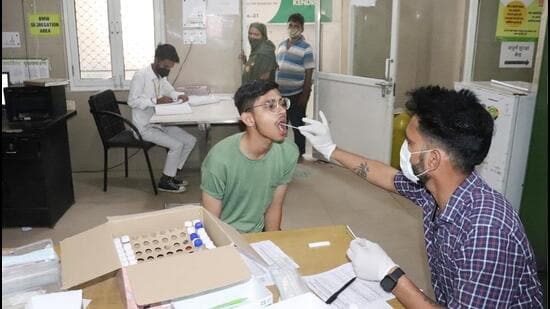 A health worker collects a swab sample for Covid testing at a hospital in Ghaziabad on Wednesday. (Sakib Ali/HT Photo)