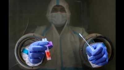 A healthcare worker takes swab sample of residents during a mock drill to check COVID-19 preparedness amid rising cases of coronavirus, at civil hospital, in Gurugram. (PTI)