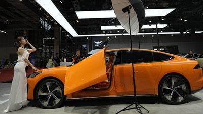 A model poses for photos near a the Y7 from Chinese automaker Yuanhang Motors during the Auto Shanghai 2023 show in Shanghai. (AP) A model poses for photos near a the Y7 from Chinese automaker Yuanhang Motors during the Auto Shanghai 2023 show in Shanghai. (AP)