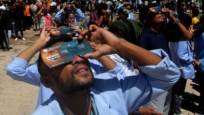People use protective glasses to watch a hybrid solar eclipse in Lautem, East Timor, Thursday, April 20, 2023. As the sun peaked behind the new moon, few lucky people either saw the darkness of a total eclipse or a “ring of fire” as the sun peeked from behind the new moon. (AP) People use protective glasses to watch a hybrid solar eclipse in Lautem, East Timor, Thursday, April 20, 2023. As the sun peaked behind the new moon, few lucky people either saw the darkness of a total eclipse or a “ring of fire” as the sun peeked from behind the new moon. (AP)