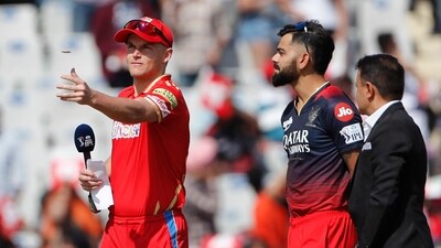 Sam Curran, left, of Punjab Kings tosses the coin for toss as Virat Kohli of Royal Challenger Bangalore's watches at the start of the Indian Premier League cricket match between Punjab Kings and Royal Challengers Bangalore in Mohali, India, Thursday, April 20, 2023. (AP Photo/Surjeet Yadav) (AP) Sam Curran, left, of Punjab Kings tosses the coin for toss as Virat Kohli of Royal Challenger Bangalore's watches at the start of the Indian Premier League cricket match between Punjab Kings and Royal Challengers Bangalore in Mohali, India, Thursday, April 20, 2023. (AP Photo/Surjeet Yadav) (AP)
