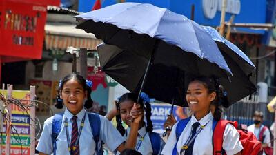 Students use umbrellas to protect themselves from the heat amid a rise in the temperature on Tuesday. (ANI Photo) Students use umbrellas to protect themselves from the heat amid a rise in the temperature on Tuesday. (ANI Photo)