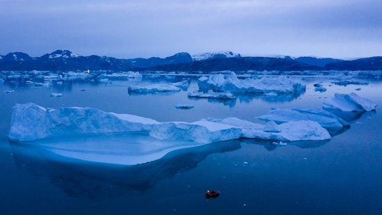A boat navigates at night next to large icebergs near the town of Kulusuk, in eastern Greenland in 2015. (AP)