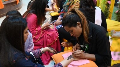 Henna artists apply mehndi on customers' hand at at a mall ahead of Eid Ul-Fitr festival in Islamabad. (AFP) Henna artists apply mehndi on customers' hand at at a mall ahead of Eid Ul-Fitr festival in Islamabad. (AFP)