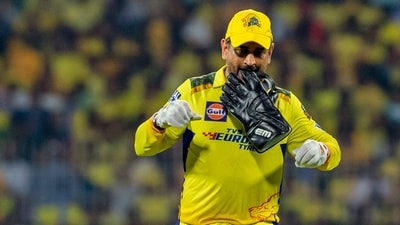 Chennai Super Kings' captain MS Dhoni holds his wicket-keeping glove between his teeth during the Indian Premier League cricket match (AP) Chennai Super Kings' captain MS Dhoni holds his wicket-keeping glove between his teeth during the Indian Premier League cricket match (AP)