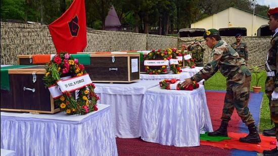 An army officer on Friday lays a wreath near the mortal remains of five soldiers who were killed in a terrorist attack in Poonch district. (PTI)
