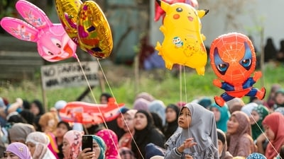 Children seen holding balloons during Eid prayers outside a mosque in Philippines' Taguig city. (Reuters)