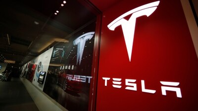 A sign bearing the Tesla company logo is displayed outside a Tesla store. (AP)