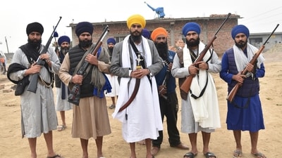 Sikh separatist leader and head of Waris Punjab De, or Punjab's Heirs, Amritpal Singh, canter in yellow turban outside a house with his supporters. (AP)