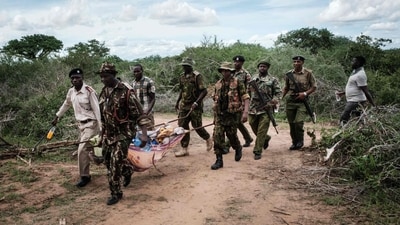 Security personnel carry a rescued young person from the forest in Shakahola, outside the coastal town of Malindi. (AFP)
