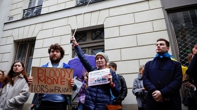 Protesters attend a demonstration outside the home of Svetlana Maniovich, the wife of the Russian Deputy Minister of Defence, to call upon French authorities to expel her, with a placard that reads "Bloody money out of France" in Paris, France, Sunday. (REUTERS)