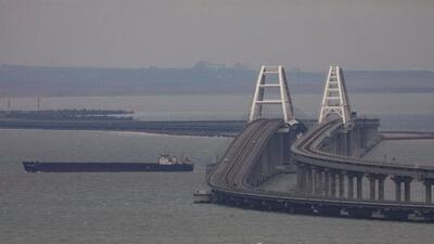 A cargo ship sails next to the Crimea bridge in the Kerch Strait, Crimea, on March 14, 2023. (REUTERS) A cargo ship sails next to the Crimea bridge in the Kerch Strait, Crimea, on March 14, 2023. (REUTERS)