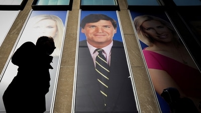 FILE PHOTO: People pass by a promo of Fox News host Tucker Carlson on the News Corporation building in New York, U.S., March 13, 2019. REUTERS/Brendan McDermid/ File Photo (REUTERS)