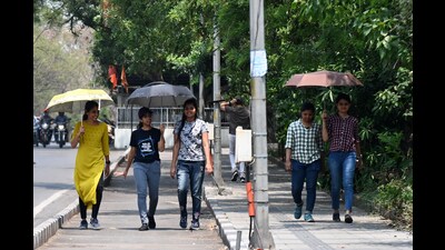 Women seen using an umbrella during a hot afternoon on Pashan NDA road on Monday. (Kalpesh Nukte/HT PHOTO)